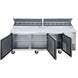 Dukers DPP90 pizza prep table with the topping rail cover open showing twelve one-third size pans