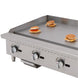 Migali Industries C-G36T 36 Inch Gas Countertop Griddle - griddle plate in use cooking burger patties, showing cooking surface and three control knobs
